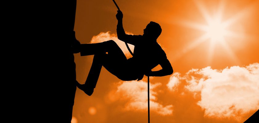 Silhouette of man climbing a mountain against sunny background Digital composition of silhouette man climbing a mountain against sunny background