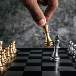 Hand of man playing chess for business planning and comparison of metaphor, selective focus